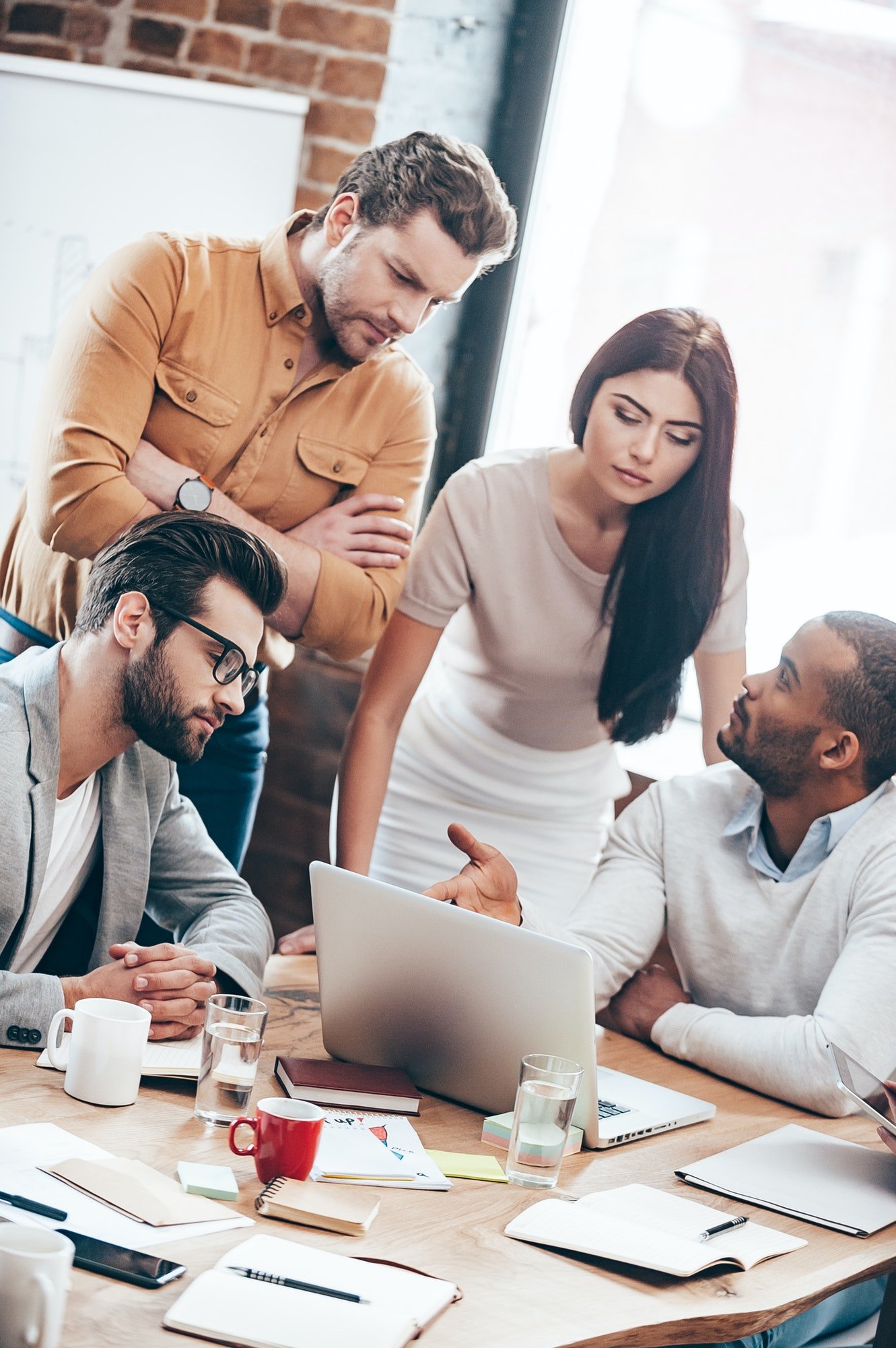 Concentrated at work group of young business people discussing something in office. Jpg