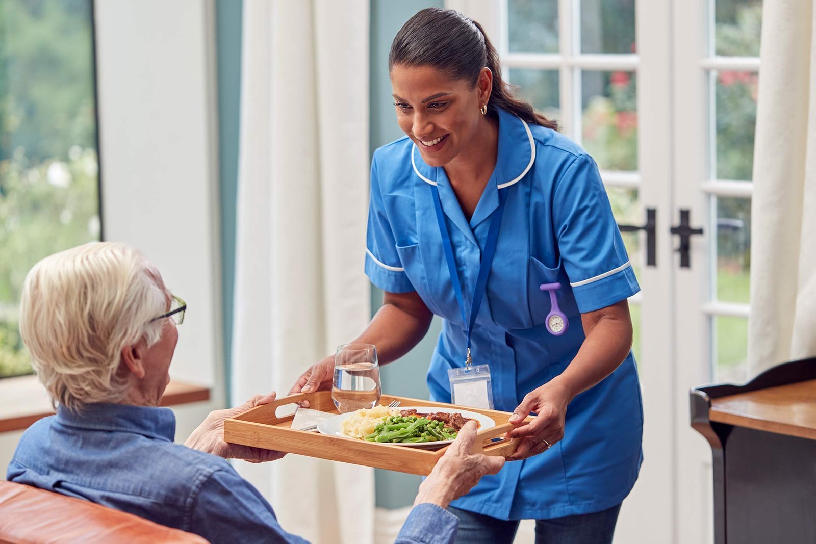 female care worker in uniform bringing meal on tra 2022 04 04 21 27 31 utc.jpg